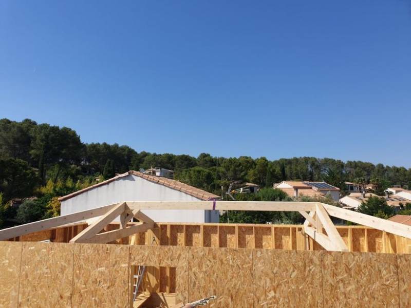 Charpente en bois traditionnelle réalisée sur une surélévation en ossature bois à clapiers, commune proche de Montpellier Hérault (34) Occitanie