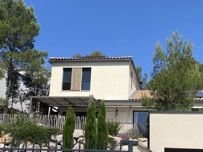 Étage supplémentaire en ossature bois avec enduit ton pierre et bardage claire-voie bois